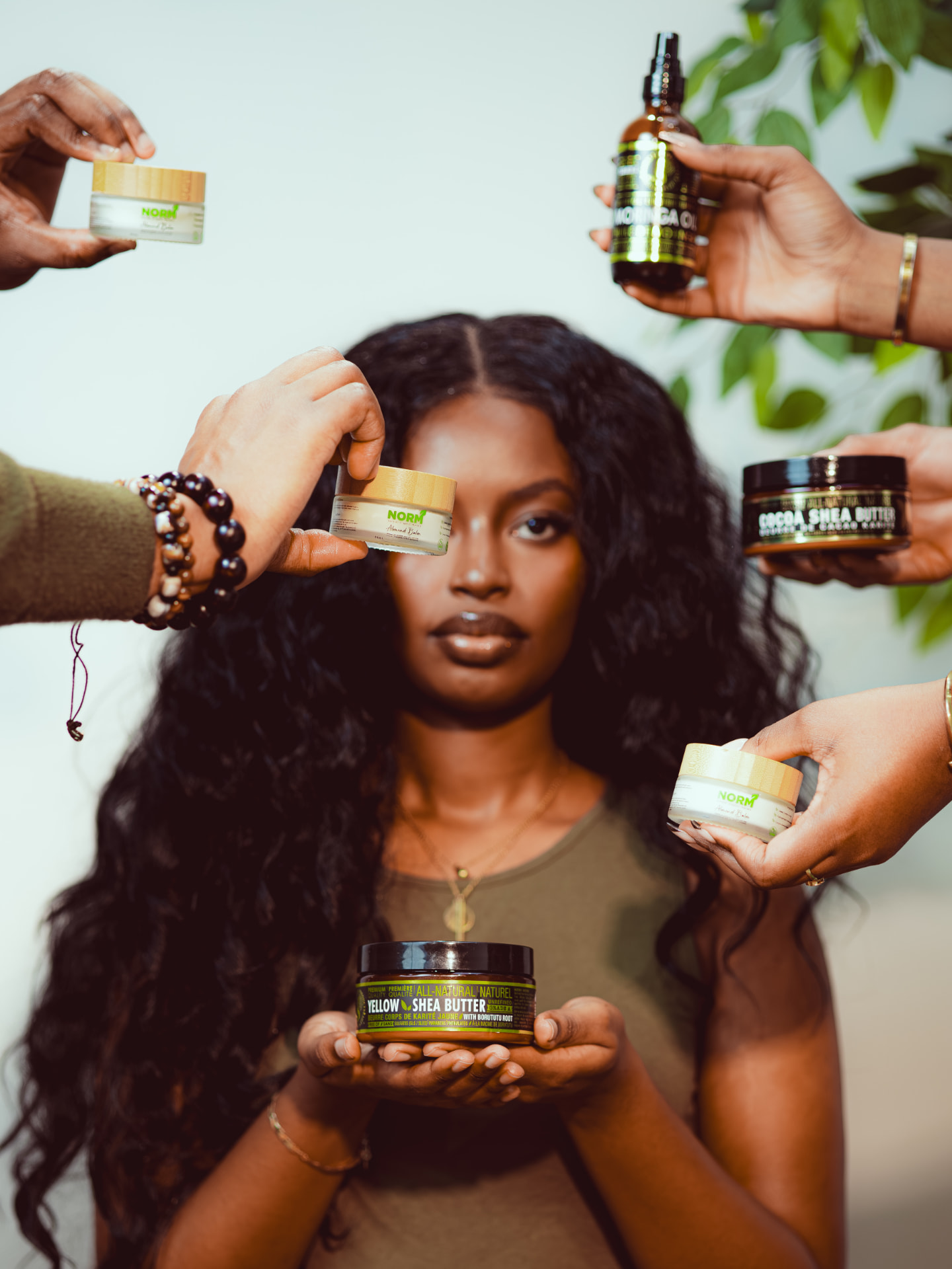 Multiple hands offering natural beauty products